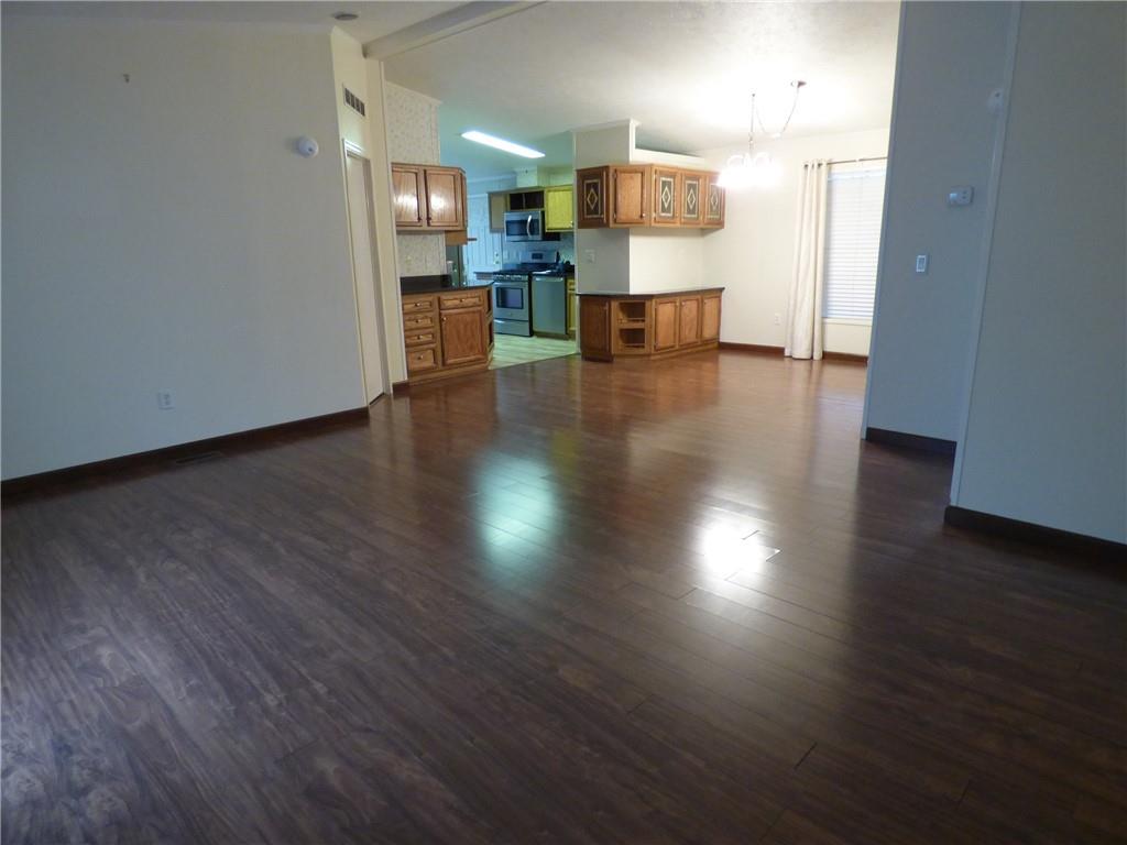 383 Eagle Lane Apollo, PA 15613 - Photo 9 of 25 an empty room with wooden floor and a kitchen