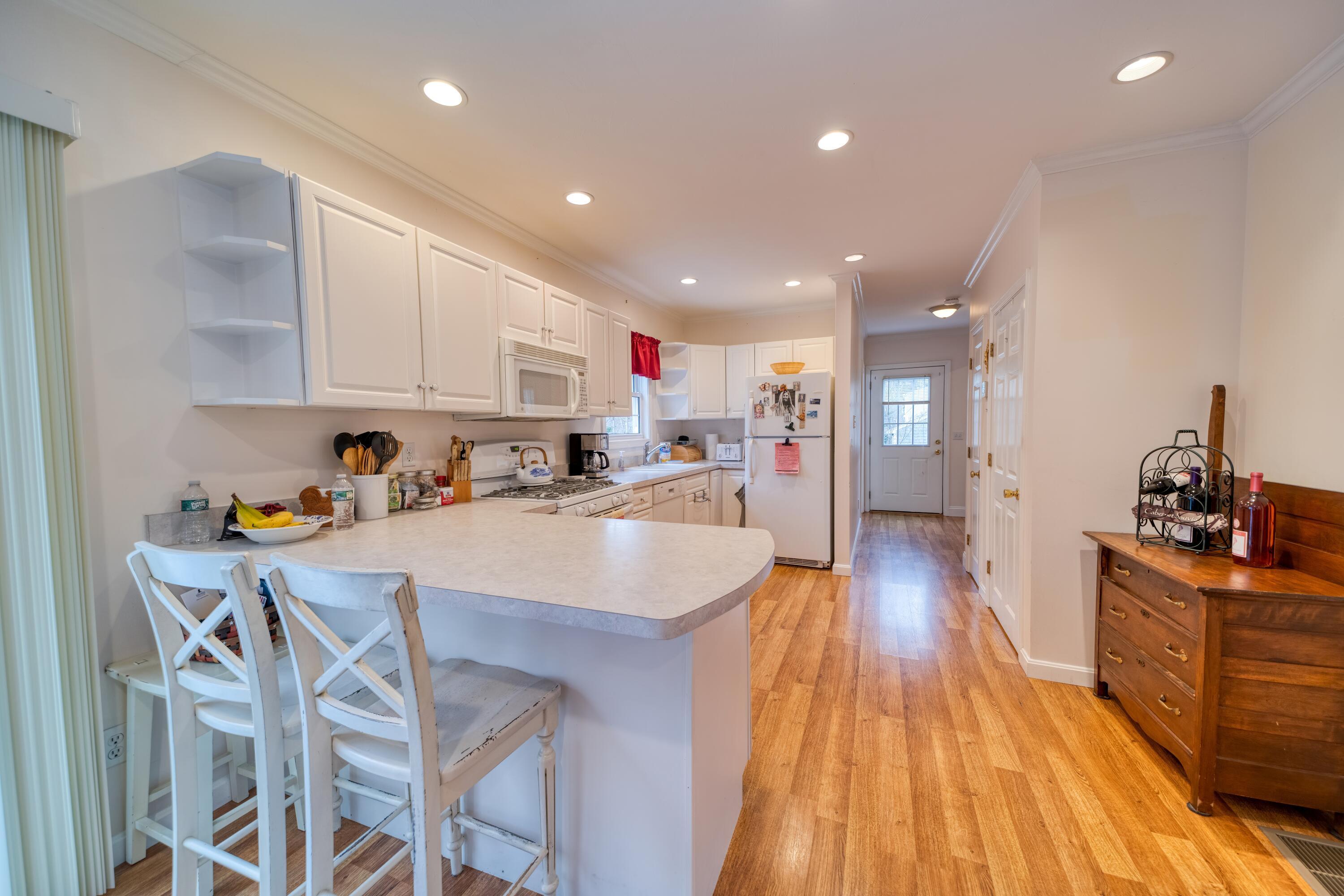 331 Cotuit Road Mashpee, MA 02649 - Photo 3 of 22 a kitchen with kitchen island wooden floors appliances and cabinets