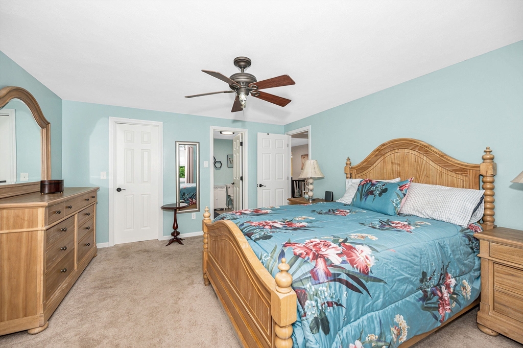 20 Chandler Drive, Unit 20 Atkinson, NH 03811 - Photo 17 of 33 a bedroom with a bed and a chandelier