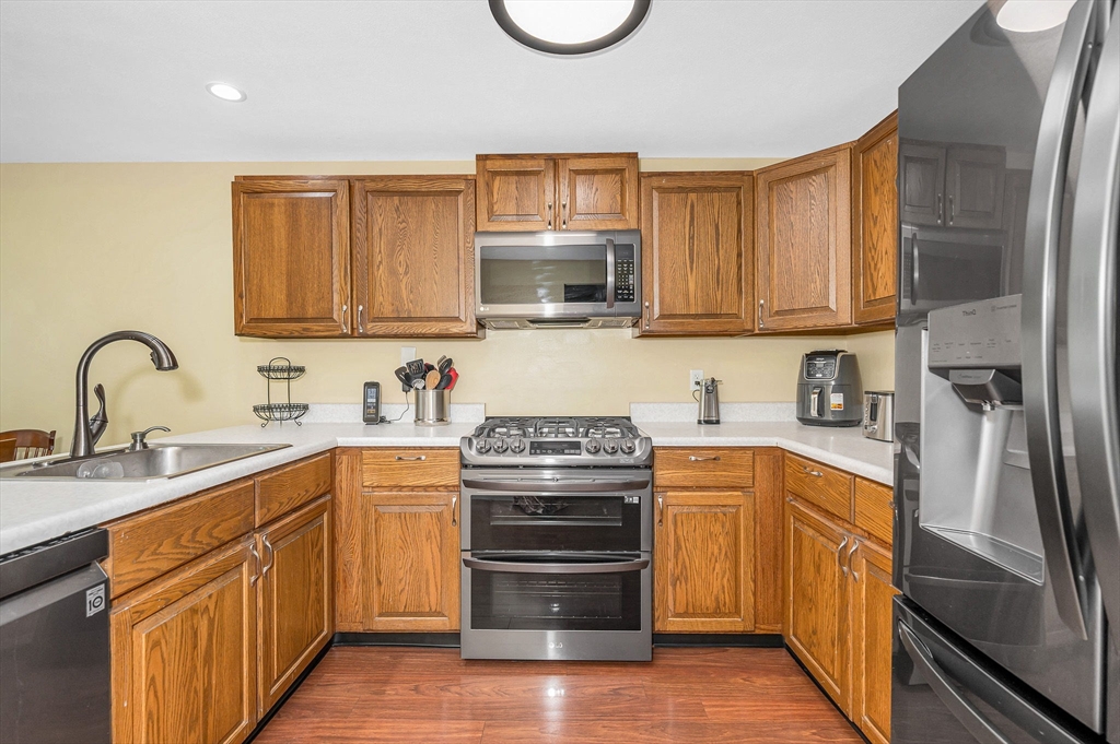 20 Chandler Drive, Unit 20 Atkinson, NH 03811 - Photo 5 of 33 a kitchen with stainless steel appliances granite countertop a stove top oven a sink and dishwasher