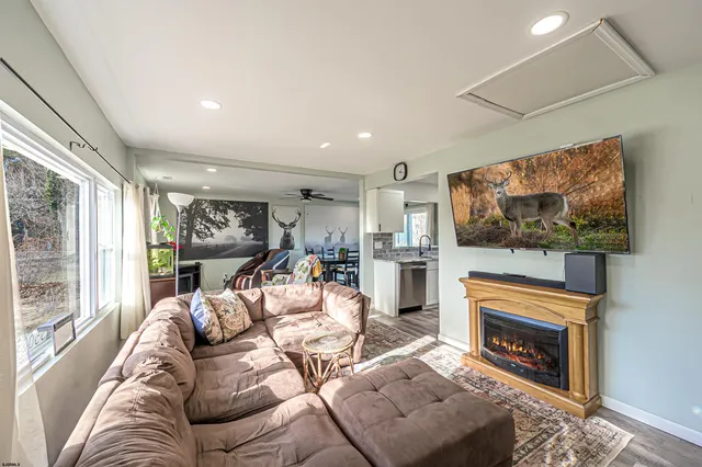 a living room with furniture a fireplace and a flat screen tv