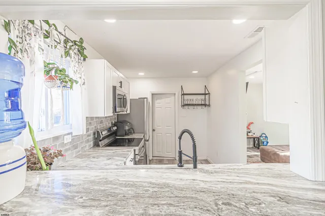 a view of a kitchen with kitchen island and stainless steel appliances