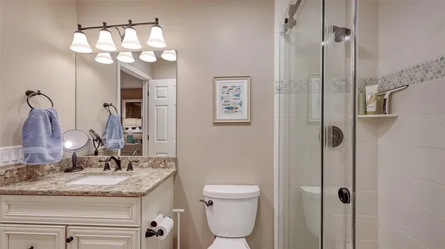 a bathroom with a granite countertop sink a toilet and a mirror