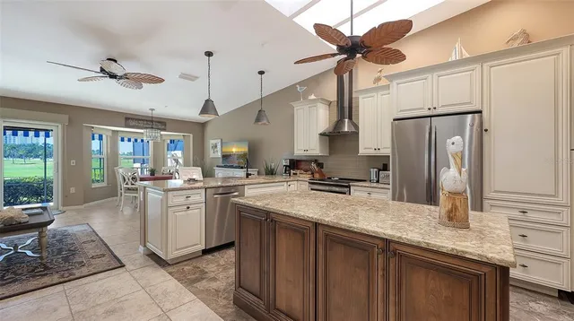 a kitchen with stainless steel appliances granite countertop a sink a stove and a refrigerator
