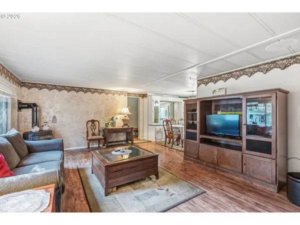 a living room with furniture a flat screen tv and a floor to ceiling window