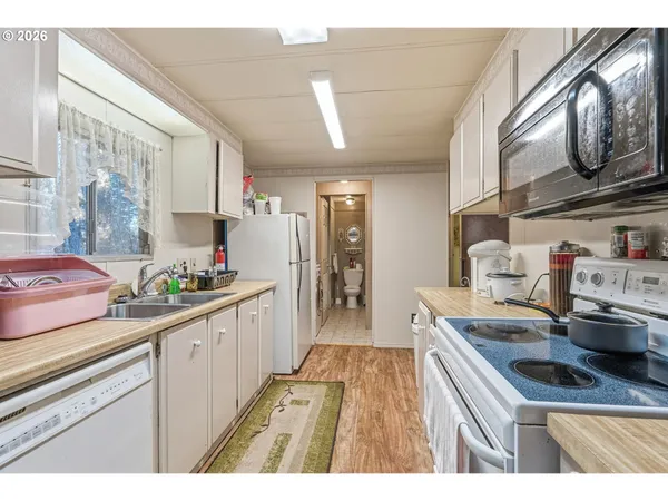 a kitchen with stainless steel appliances granite countertop a sink stove and cabinets