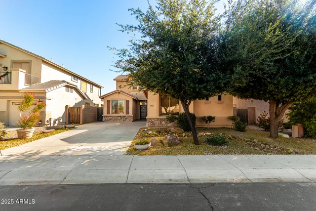 a view of a white house next to a road and yard
