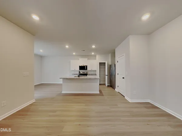 a view of kitchen with kitchen island a sink wooden floor and a counter top space