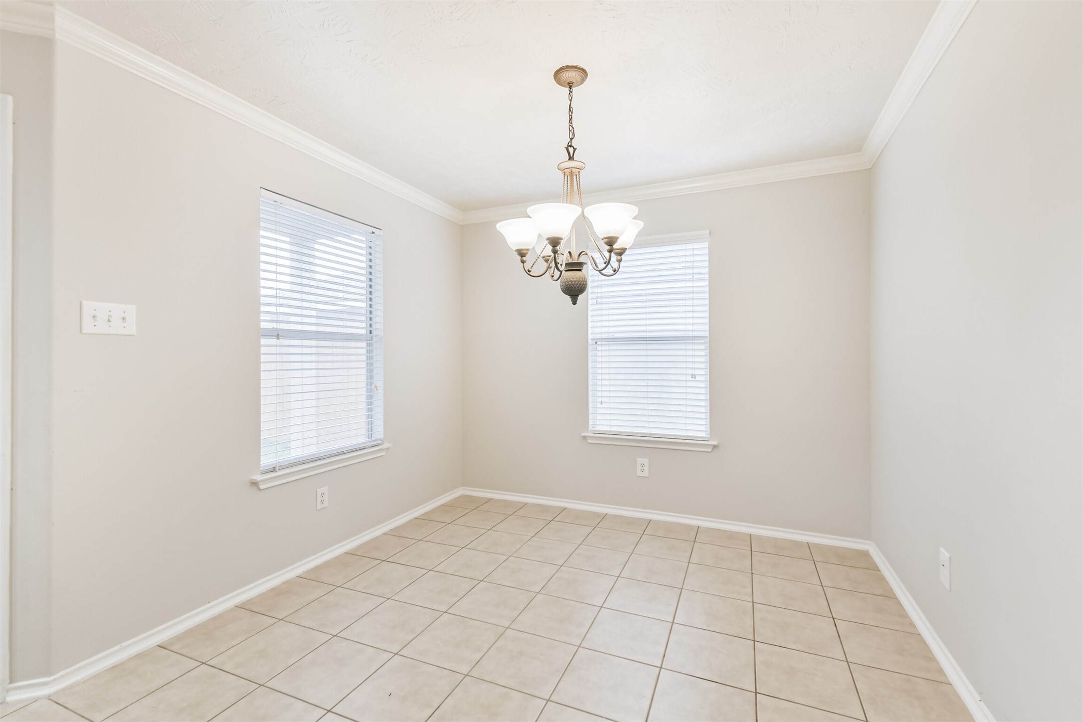15023 Roche Rock Drive Humble, TX 77396 - Photo 14 of 40 an empty room with windows and chandelier
