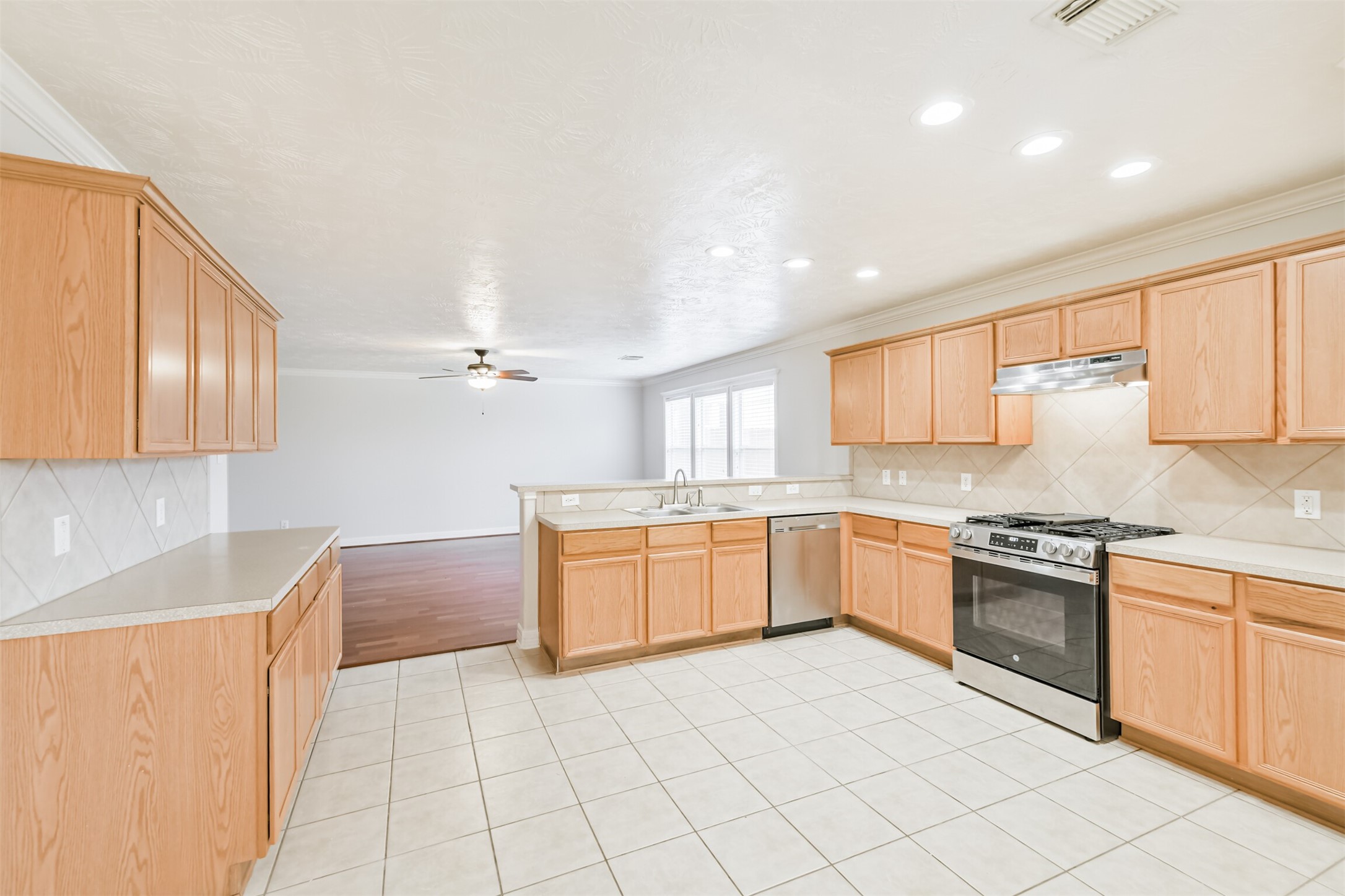 15023 Roche Rock Drive Humble, TX 77396 - Photo 9 of 40 a large kitchen with granite countertop white cabinets a sink a stove a dining table and chairs