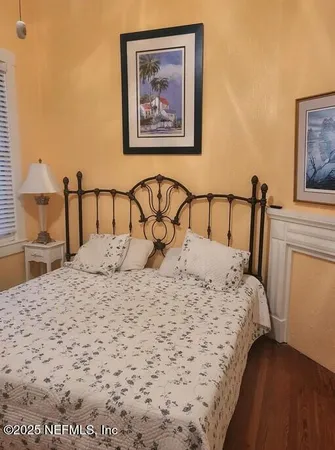 a bedroom with a bed and a painting on the wall