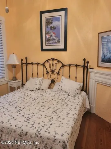 a bedroom with a bed and a painting on the wall