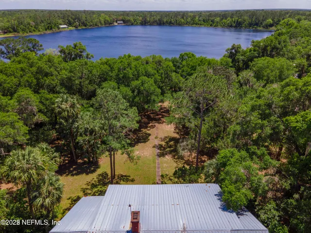 an aerial view of a house with a yard and lake view