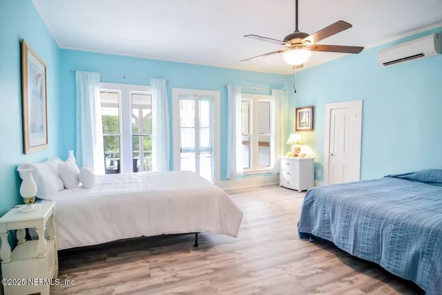 a bedroom with a large bed chandelier and a window