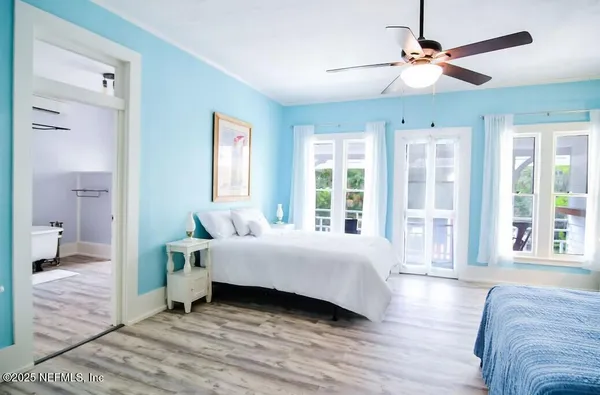 a spacious bedroom with a bed ceiling fan and a window