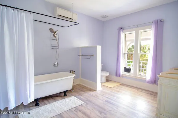 a bathroom with a bathtub a shower and a window