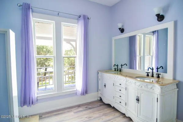 a bathroom with a double vanity sink window and mirror