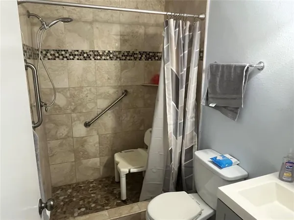 a bathroom with a shower a toilet and a sink