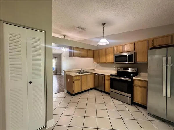 a kitchen with stainless steel appliances granite countertop a refrigerator and a stove top oven