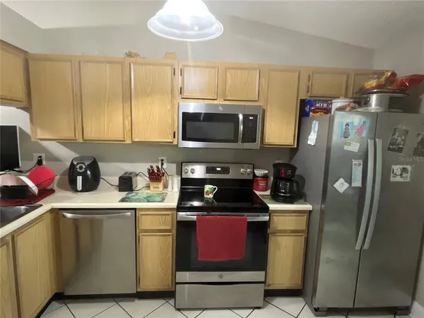 a kitchen with stainless steel appliances granite countertop a refrigerator a stove a sink dishwasher and microwave with cabinets