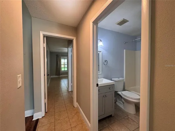 a bathroom with a granite countertop toilet a sink and a mirror