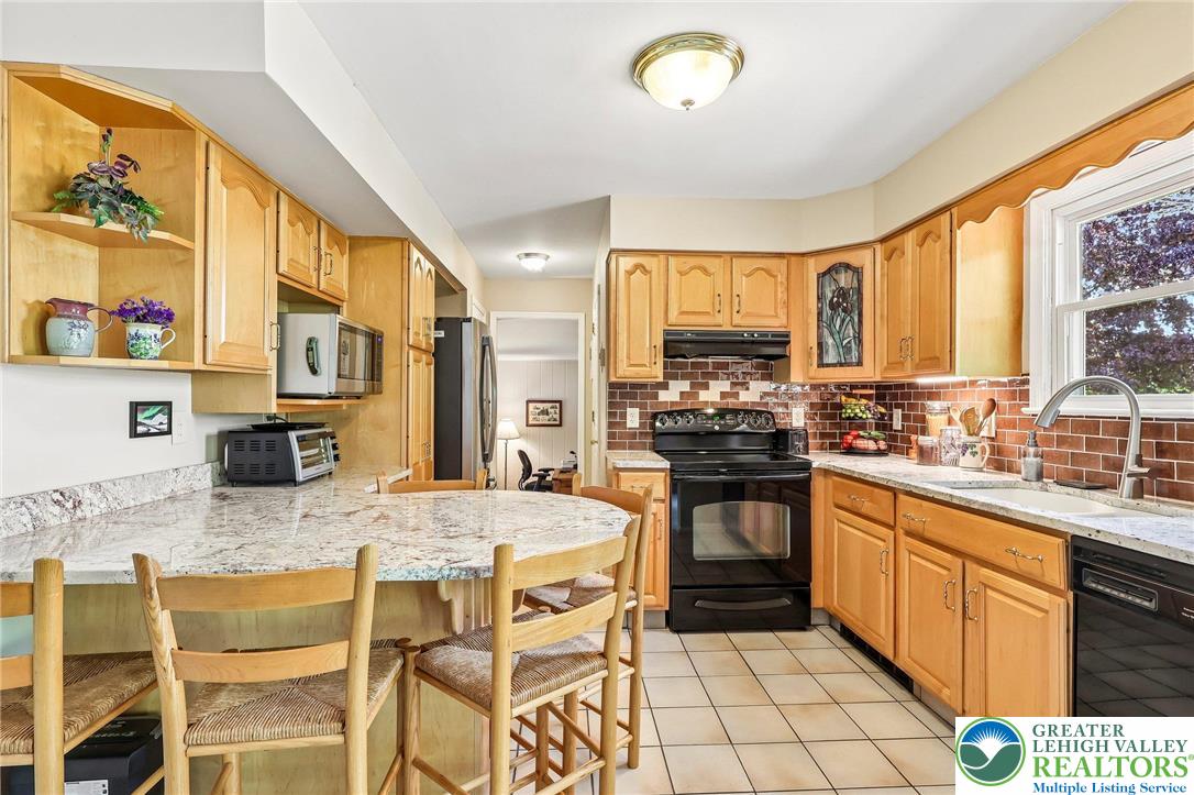 574 Carol Lane Bath, PA 18014 - Photo 13 of 46 a kitchen with stainless steel appliances granite countertop a stove a sink dishwasher and a refrigerator with wooden cabinets