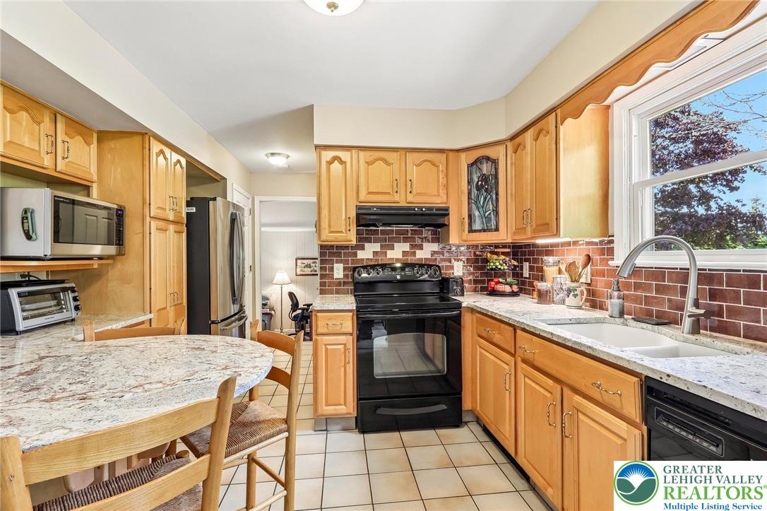 574 Carol Lane Bath, PA 18014 - Photo 15 of 46 a kitchen with stainless steel appliances granite countertop a stove top oven a sink dishwasher and cabinets with wooden floor