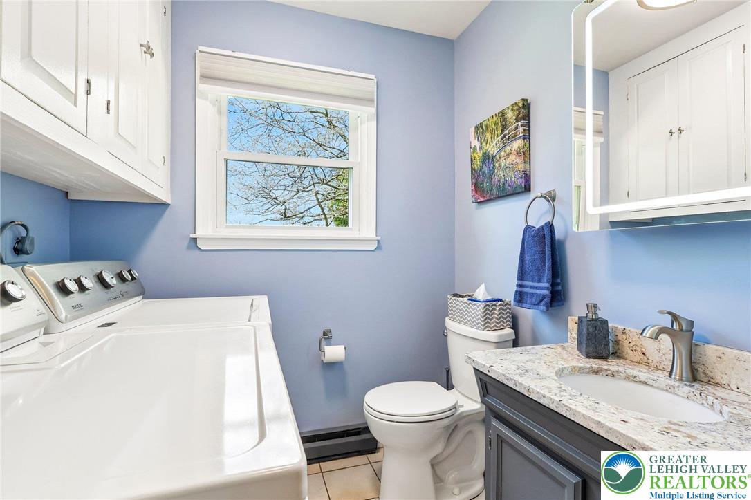 574 Carol Lane Bath, PA 18014 - Photo 16 of 46 a bathroom with a granite countertop sink a toilet and a window