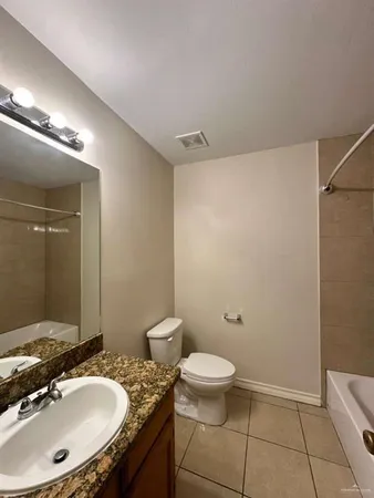 a bathroom with a granite countertop sink a toilet a mirror and shower