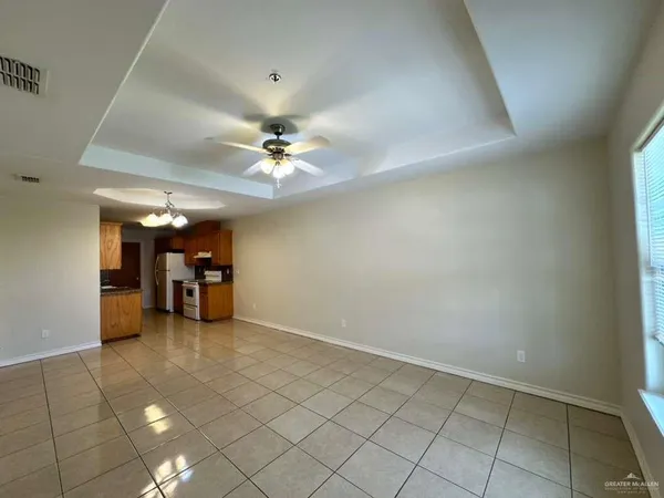 an empty room with fireplace and chandelier fan