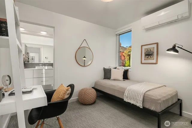 a bedroom with a bed a mirror and a lamp on dresser