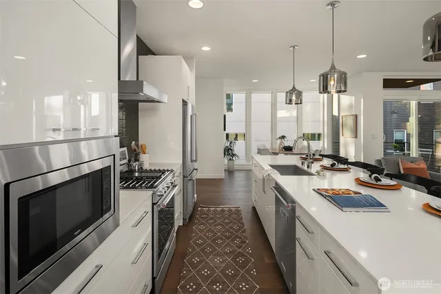 a kitchen with a sink stove and wooden floor