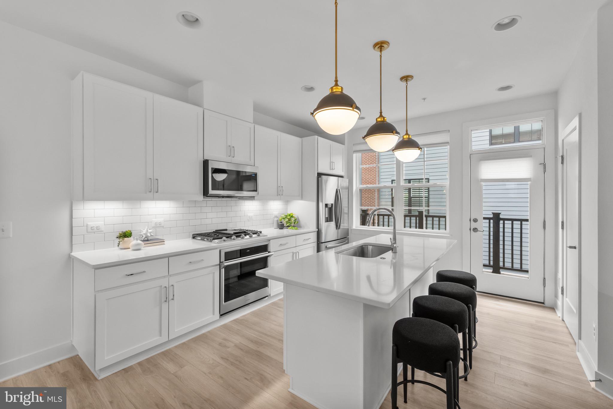 1891 Midline Avenue Reston, VA 20190 - Photo 3 of 53 a large kitchen with stainless steel appliances granite countertop a stove a sink dishwasher a dining table and chairs with wooden floor