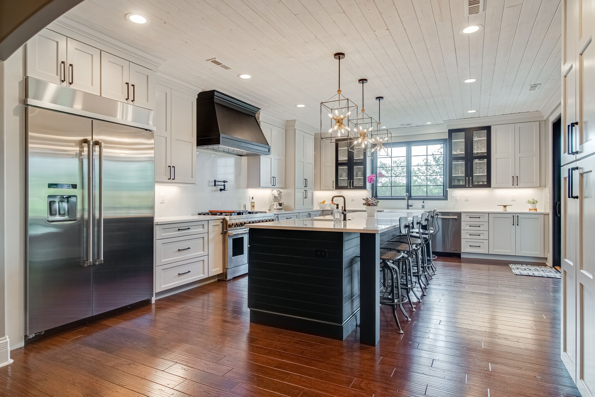 297 Vanderbilt Road Mount Juliet, TN 37122 - Photo 10 of 50 a kitchen with stainless steel appliances kitchen island granite countertop a refrigerator a stove a sink a dining table and chairs with wooden floor