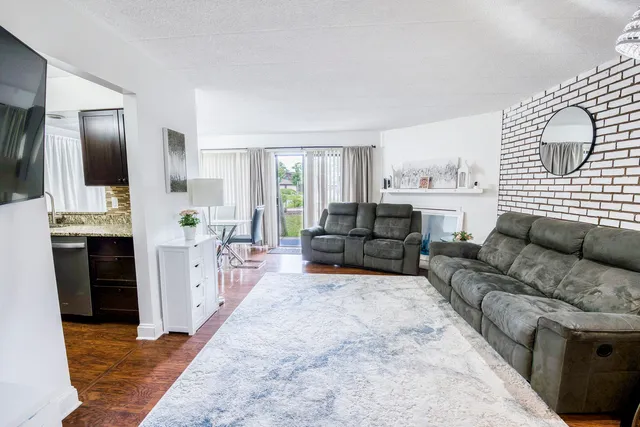 a living room with furniture a fireplace and a flat screen tv