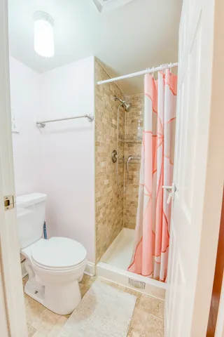 a white toilet sitting next to a bath tub