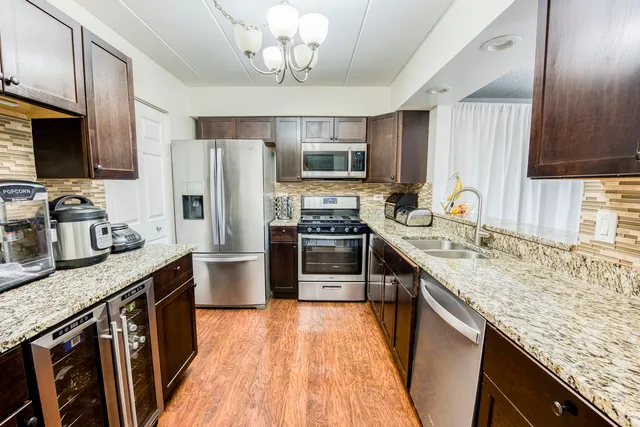 a kitchen with stainless steel appliances granite countertop a sink stove and refrigerator