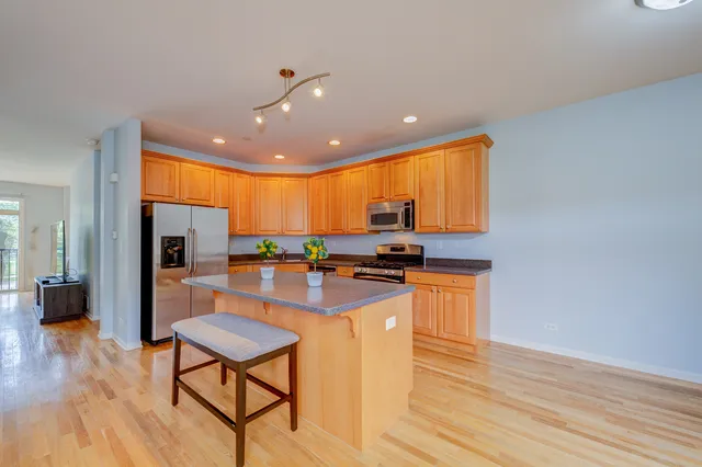 a kitchen with stainless steel appliances granite countertop a stove and a wooden floors