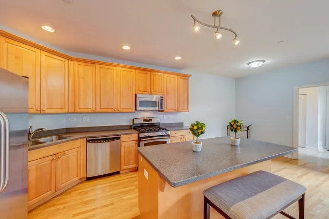 a kitchen with stainless steel appliances granite countertop a sink a stove and a refrigerator