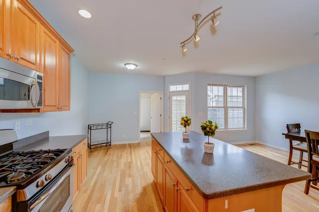 a kitchen with stainless steel appliances granite countertop a lot of counter space and wooden floors