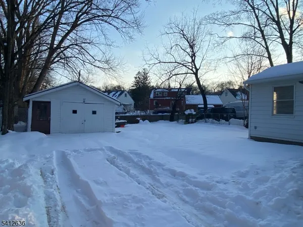 a view of a house with a yard covered in snow