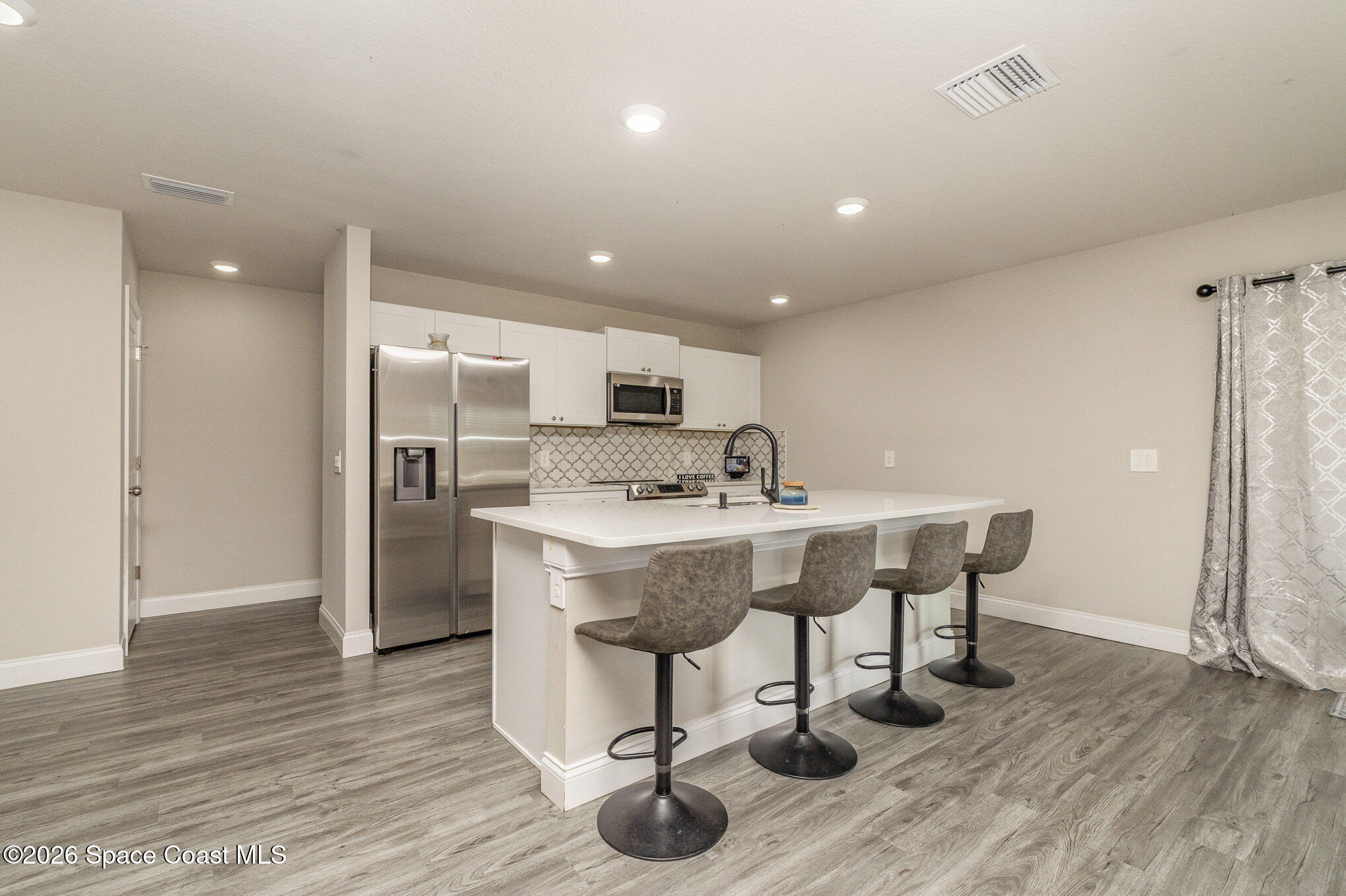 866 Carnival Road Southeast Palm Bay, FL 32909 - Photo 15 of 28 a view of a kitchen with dining area a sink a refrigerator and wooden floor