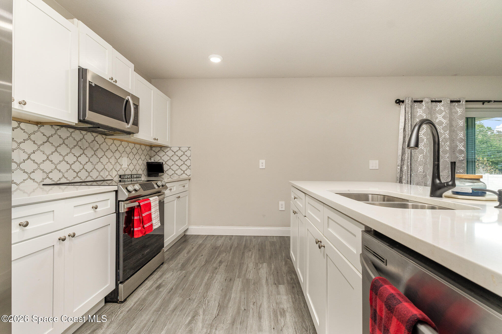 866 Carnival Road Southeast Palm Bay, FL 32909 - Photo 16 of 28 a kitchen with granite countertop a stove and a sink