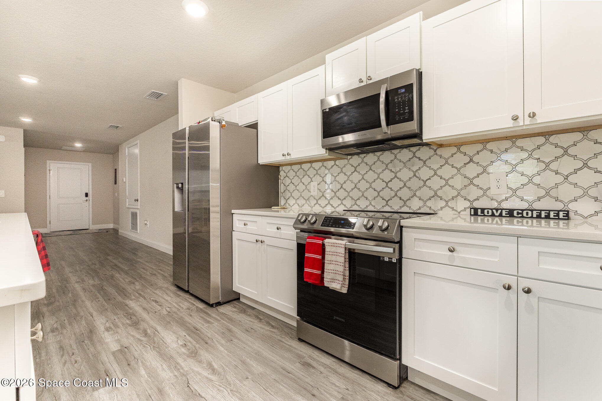 866 Carnival Road Southeast Palm Bay, FL 32909 - Photo 17 of 28 a kitchen with stainless steel appliances granite countertop a stove a microwave and a refrigerator