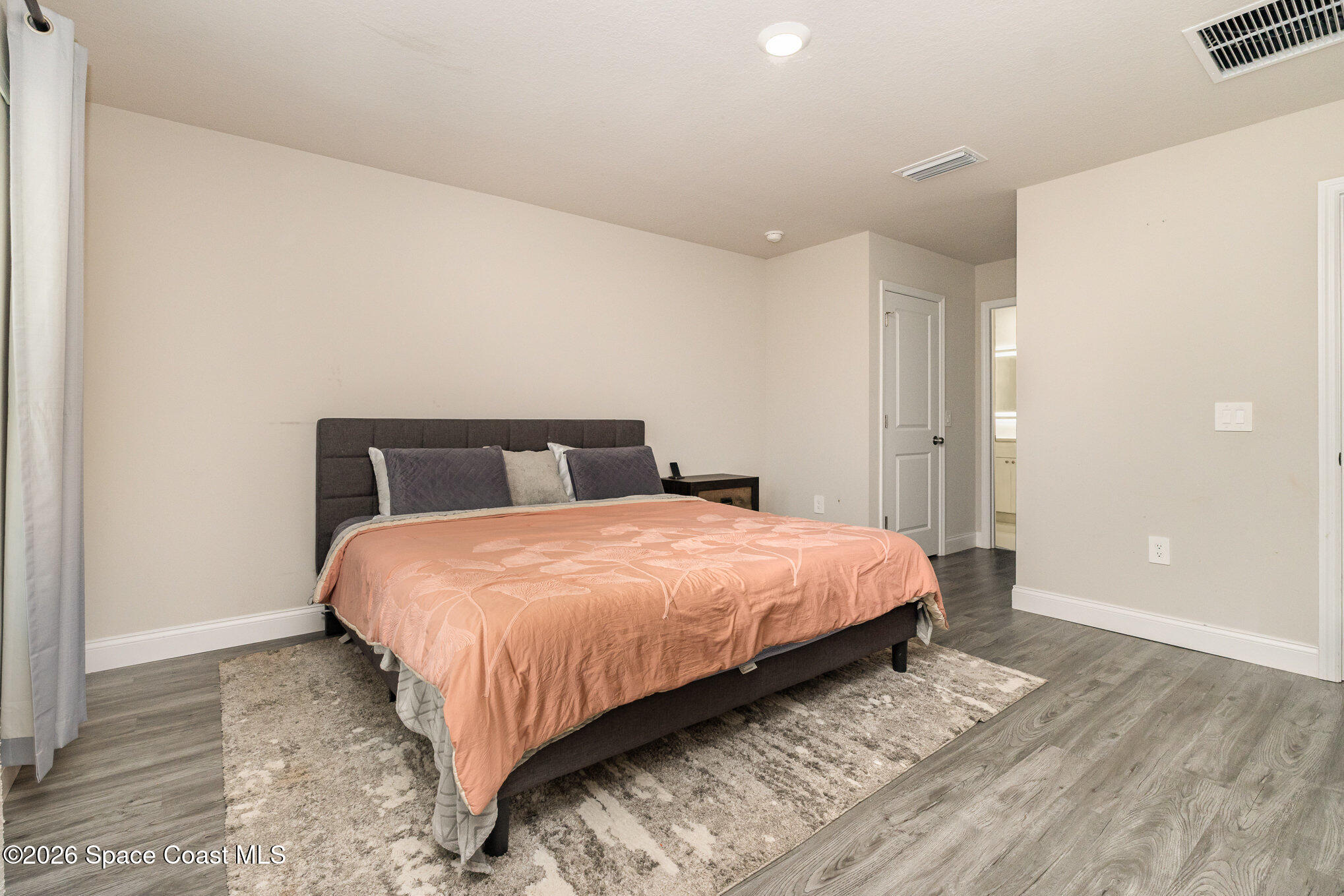 866 Carnival Road Southeast Palm Bay, FL 32909 - Photo 19 of 28 a bedroom with a bed and wooden floor