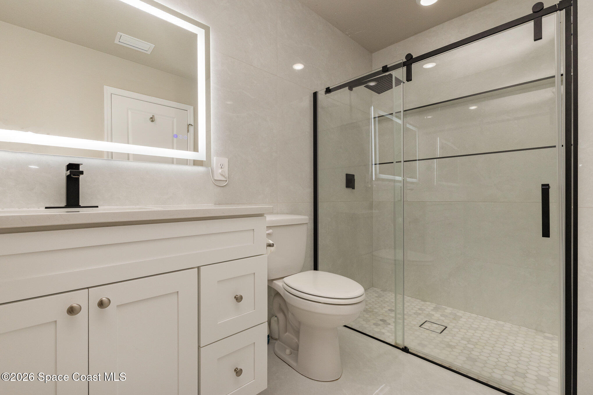 866 Carnival Road Southeast Palm Bay, FL 32909 - Photo 20 of 28 a bathroom with a shower sink vanity and toilet