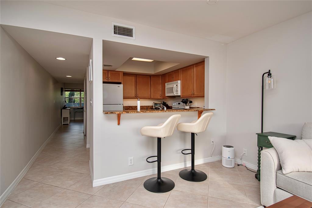 9500 Southwest 3rd Street, Unit 248 Boca Raton, FL 33428 - Photo 11 of 47 a kitchen with stainless steel appliances kitchen island granite countertop a sink a table and chairs