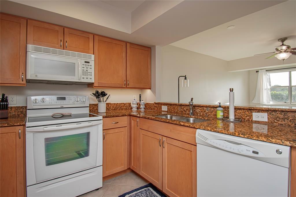 9500 Southwest 3rd Street, Unit 248 Boca Raton, FL 33428 - Photo 13 of 47 a kitchen with granite countertop cabinets stainless steel appliances and a sink