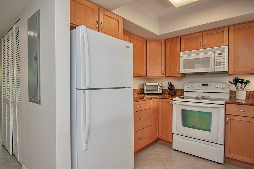 9500 Southwest 3rd Street, Unit 248 Boca Raton, FL 33428 - Photo 15 of 47 a kitchen with cabinets stainless steel appliances and a refrigerator