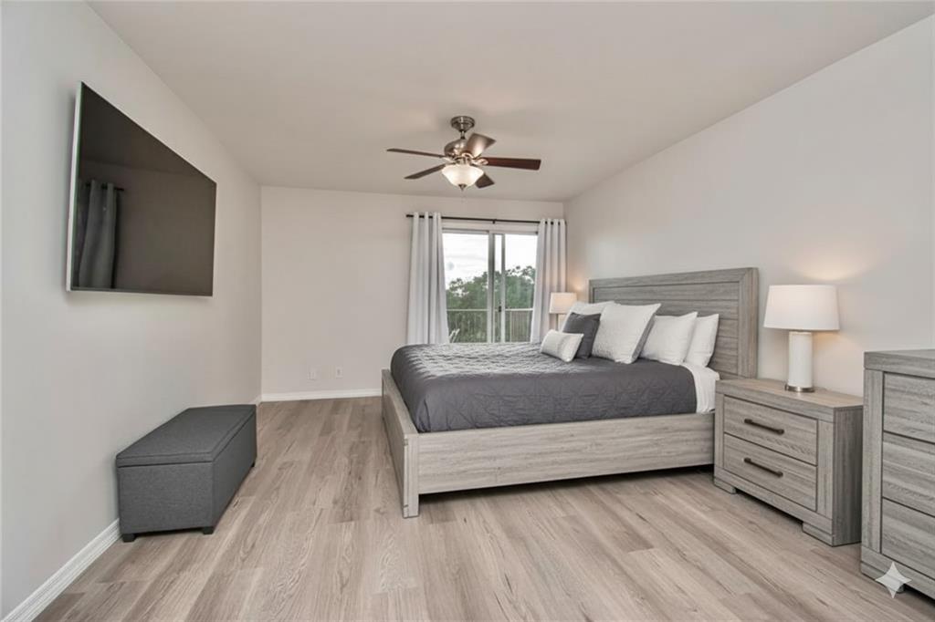 9500 Southwest 3rd Street, Unit 248 Boca Raton, FL 33428 - Photo 19 of 47 a bedroom with a bed chandelier and a window